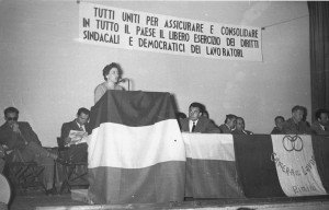 Anni ’50. Rimini. Iniziativa della CGIL. Al microfono Elda Codeluppi Zanuccoli. Il primo alla sua destra Walter Ceccaroni 